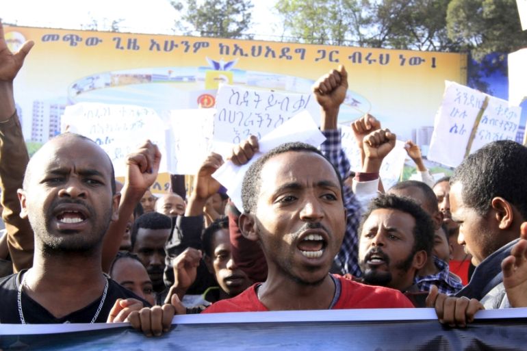 People hold a poster showing Ethiopians being killed by Islamic State militants in Libya, as they mark the start of a three-day national moaning period