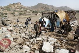 People gather on the wreckage of a house destroyed by an air strike in the Bait Rejal village west of Yemen''s capital Sanaa