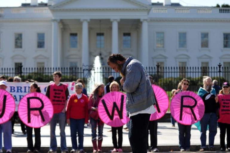 A Muslim man prays as anti-war protesters demonstrate in front of the White House in Washington, DC [Getty]