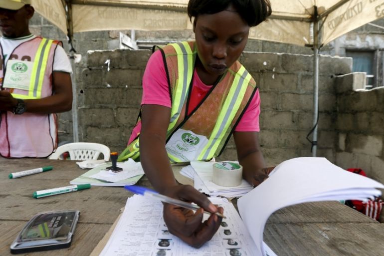 An electoral officer checks through a list for verification of a voter''s name during governorship election in Ajah district of Lagos
