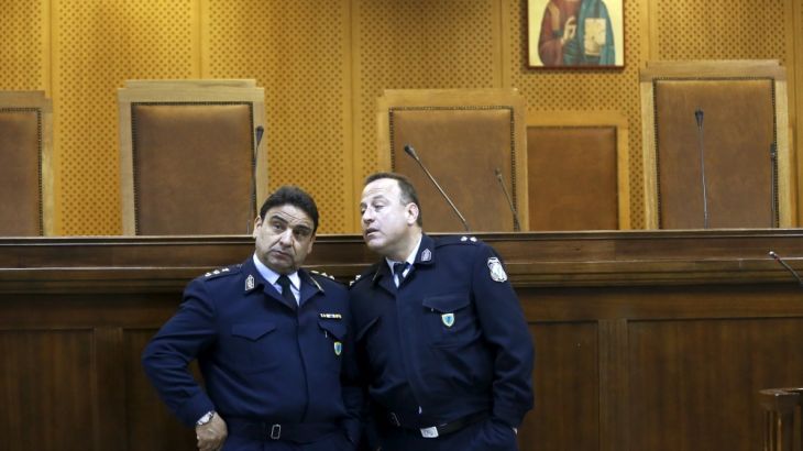 Two police officers are seen inside the court room where the trial of the leaders of Greece's far-right Golden Dawn party takes place, in Koridallos prison