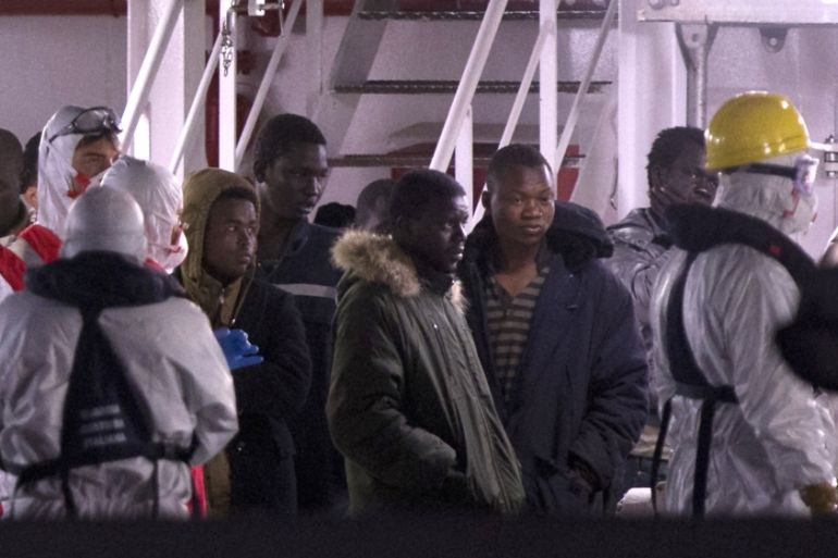 Survivors of the boat that overturned off the coasts of Libya Saturday, wait to disembark from Italian Coast Guard ship Bruno Gregoretti, at Catania Harbor, Italy [AP]