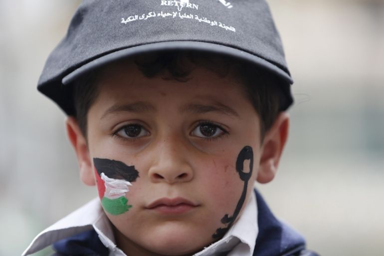 A Palestinian boy has his face painted with a Palestinian flag and a key as he takes part in a rally ahead of Nakba day, in the West Bank city of Ramallah [REUTERS]