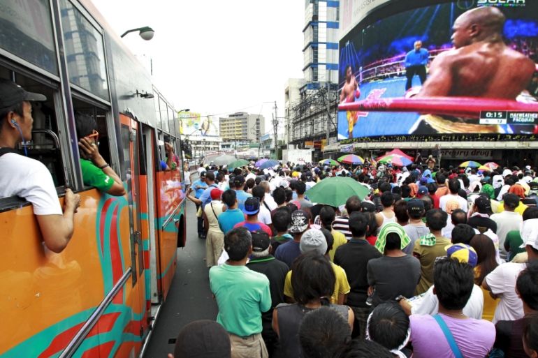 Fans watch the fight on a live telecast monitor along a busy street in Manila [REUTERS]