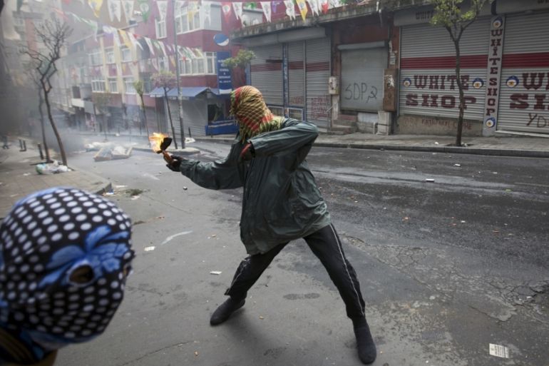 A protester throws a Molotov cocktail during clashes with police in Okmeydani neighborhood in Istanbul