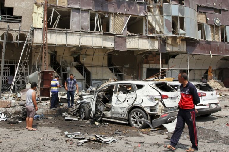 People look at at the site of a car bomb attack in Baghdad