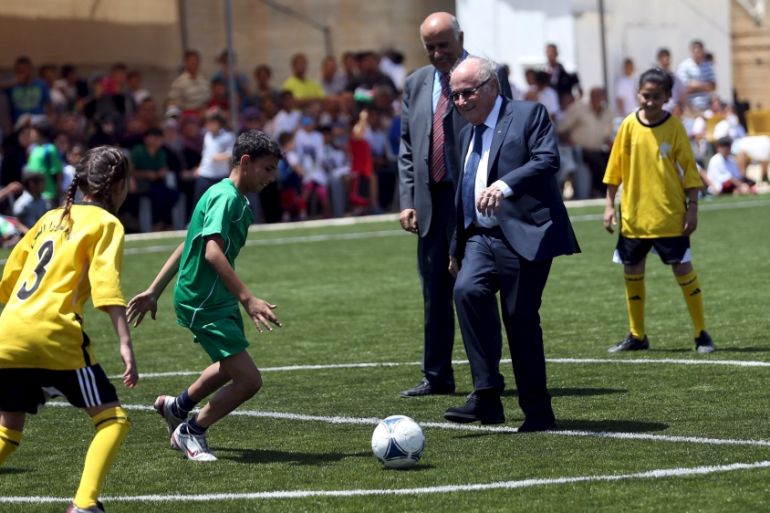 FIFA chief Sepp Blatter plays soccer with Palestinian children during his visit to Dura al-Qar'' village in the West Bank city of Ramallah
