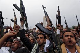 Houthi followers hold up their weapons during a demonstration against the Saudi-led air strikes, in Sanaa