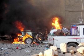 A car is engulfed by flames during clashes in the city of Ramadi