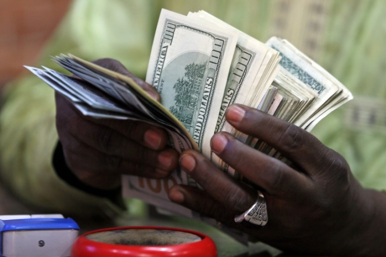 A bureau de change operator counts U.S. currency notes in Abuja