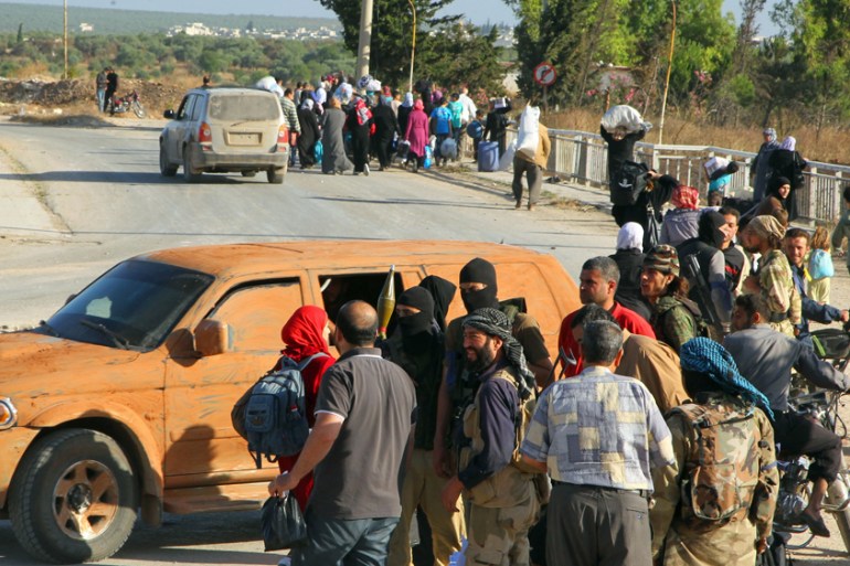 Members of al Qaeda''s Nusra Front stop residents at a checkpoint for identification as they flee the northwestern city of Ariha, after a coalition of insurgent groups seized the area in Idlib province