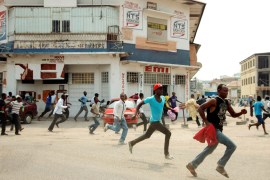 Protesters run in a street of Kinshasa