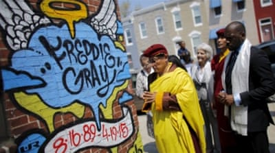 A Buddhist leader from South Asia prays at the spot where Freddie Gray was arrested in Baltimore [REUTERS]