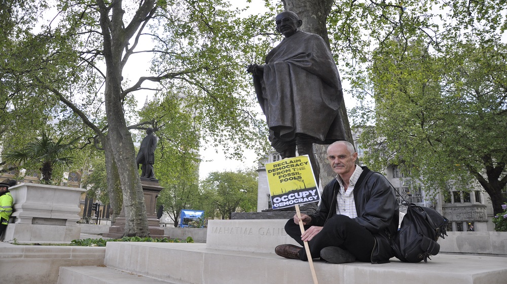 Donnachadh McCarthy accused police of roughing him up as he protested in front of a statue of Gandhi [Simon Hooper/Al Jazeera]