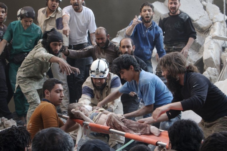 Syrian rescue workers and citizens carry a child on a stretcher from a building following a reported barrel bomb attack by Syrian government forces in Aleppo [AFP]