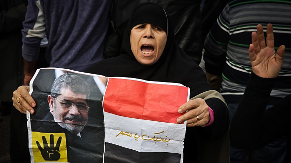 
A supporter of the Muslim Brotherhood movement holds a placard showing Morsi during a demonstration [Getty Images]
