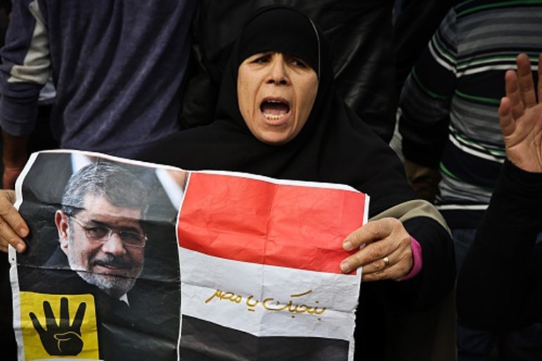 A supporter of the Muslim Brotherhood movement holds a placard showing Morsi during a demonstration in January [AFP]