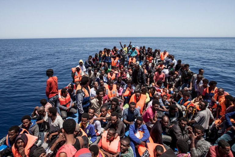 Migrants crowd the deck of their wooden boat off the coast of Libya