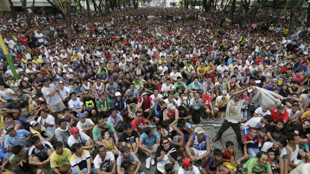 Filipinos at Marikina city cheer during a live satellite broadcast from Las Vegas of the welterweight boxing title fight [AP]