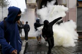 Demonstrators prepare to throw stones against riot policemen during clashes, as Chile''s President Michelle Bachelet delivers a speech inside the National Congress, in Valparaiso city