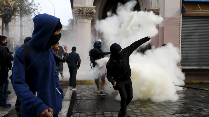 Demonstrators prepare to throw stones against riot policemen during clashes, as Chile''s President Michelle Bachelet delivers a speech inside the National Congress, in Valparaiso city