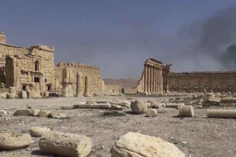 Smoke rises behind archaeological ruins in Palmyra, Syria [AP]