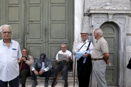 Pensioners wait for the opening of a National Bank branch to receive their monthly pensions in Athens [REUTERS]