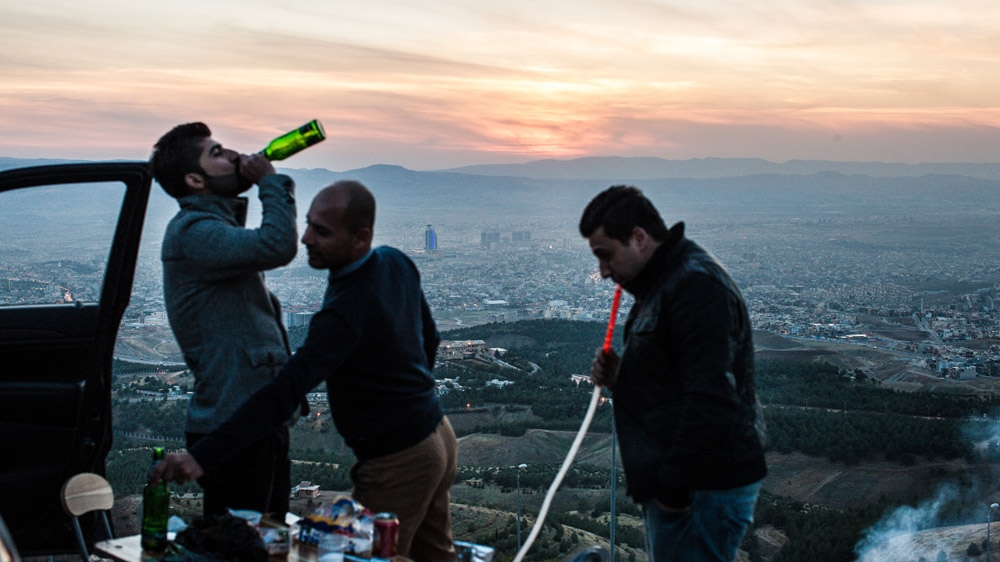 Young Kurdish men drink beer and smoke a water pipe atop a mountain overlooking Sulaymaniyah [Mackenzie Knowles-Coursin]