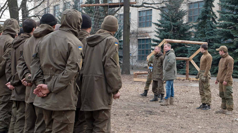 Mikael Skillt [shown centre in jeans] conducts training for new Azov recruits at the regiment's training centre in Kiev [Christopher Allen/Al Jazeera]