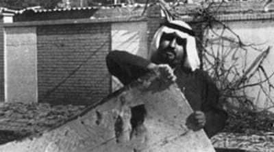 A Kuwaiti man picks up debris outside the US embassy in Kuwait after a bomb blast in 1982 [AFP]