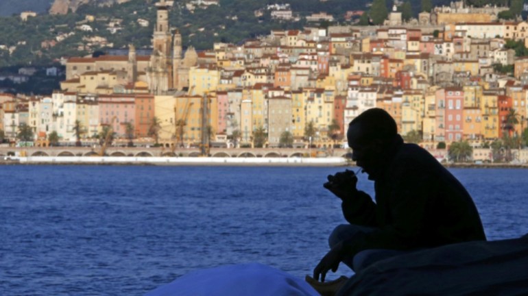 A migrant is silhouetted at the Saint Ludovic border crossing on the Mediterranean Sea