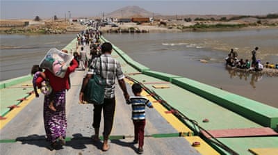Displaced Iraqis cross the Iraq-Syria border over   the   Tigris River [AP]