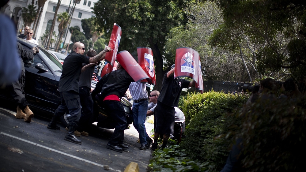 National Socialist Movement members try to protect themselves from rocks and glass being thrown by counter-protesters as they leave their rally on the steps of Los Angeles, City Hall. April 2010 [Julie Platner]