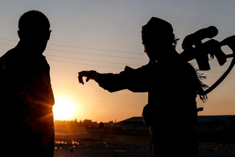 Members of Kurdish People Defence Units (YPG) guard during a sunset near Tel Abyad border gate northern Syria [EPA]