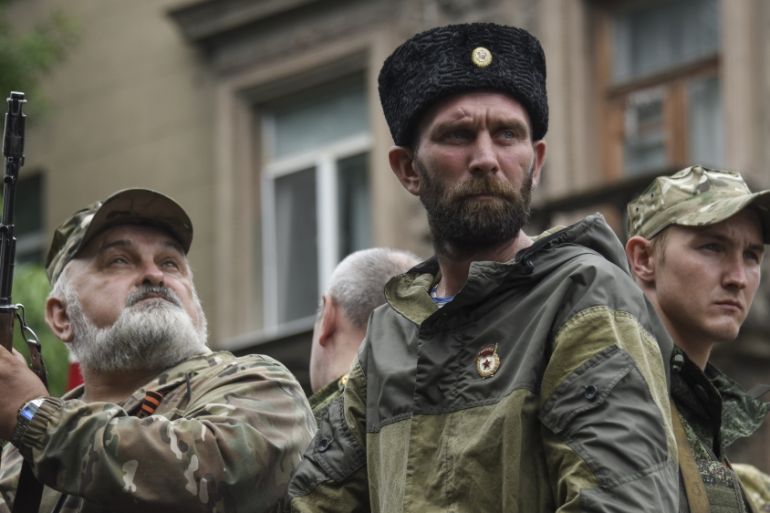 Pro-Russia rebels stand guard during funeral of prominent