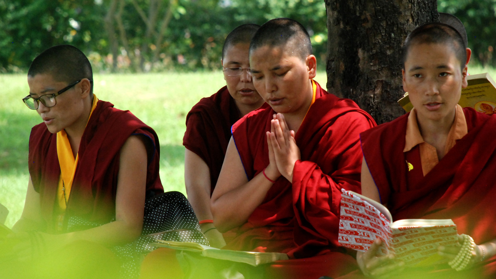 Buddhist monks chant mantras in the grounds of the Maya Devi temple in Lumbini, Nepal, regarded as the birthplace of Buddha [Ingrid Piper/Al Jazeera]