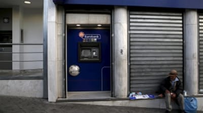 A man sells napkins by an ATM that was emptied by people withdrawing cash, in Athens [REUTERS]