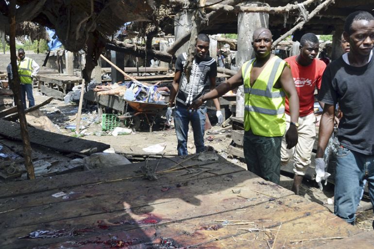 Rescue workers at the site of a suicide bomb attack at a market in Maiduguri , Nigeria