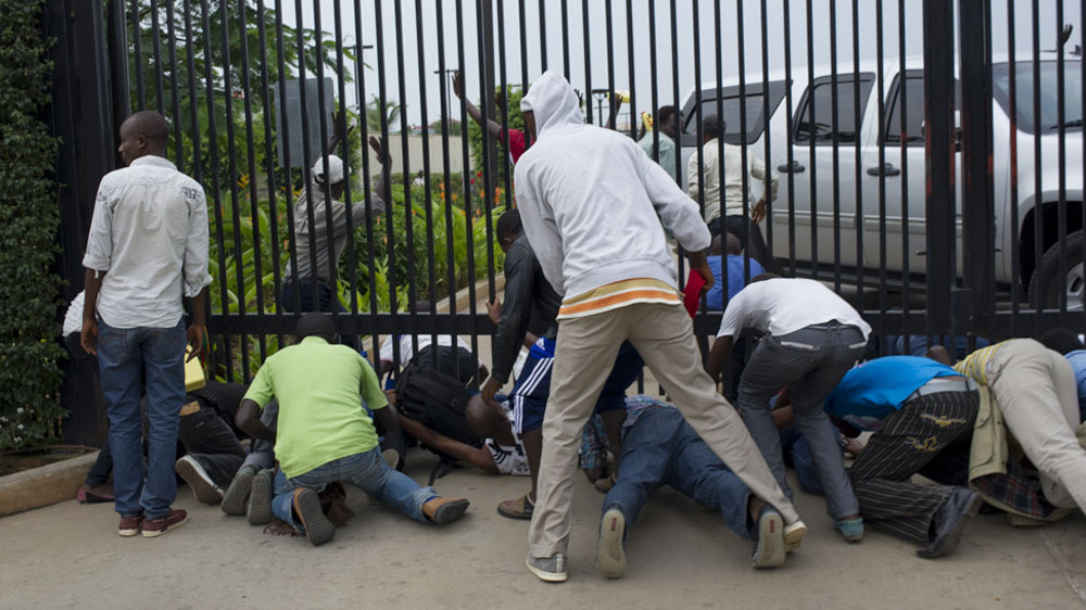 Students rush under the gate to the US embassy as police arrive to forcibly remove them [Phil Moore/Al Jazeera] 