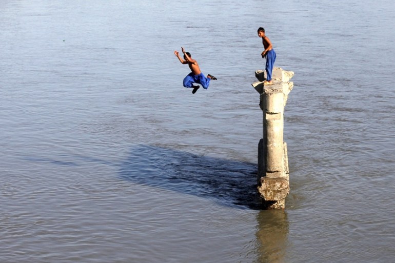 A boy jumps into the Sardaryab River to beat the scorching heat in Peshawar, Pakistan