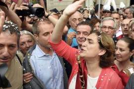 The new mayor of Barcelona Ada Colau waves to the people as she crosses Sant Jaume square to meet Catalonia''s regional president at the Generalitat palace [AFP]