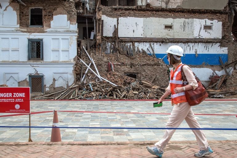 A delegate walks in front of a damaged palace during their visit to Basantapur Durbar Square ahead of International Donors'' Conference [Getty]