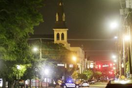 The steeple of Emanuel AME Church is visible as police close off a section of Calhoun Street following a shooting in Charleston [AP]