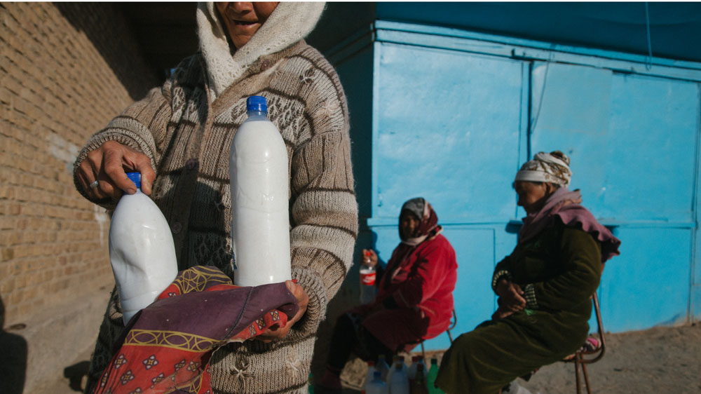Elderly women sell milk at the bazaar in Muynak. Local residents rely on upriver supplies for fresh produce [Timur Karpov/Al Jazeera]