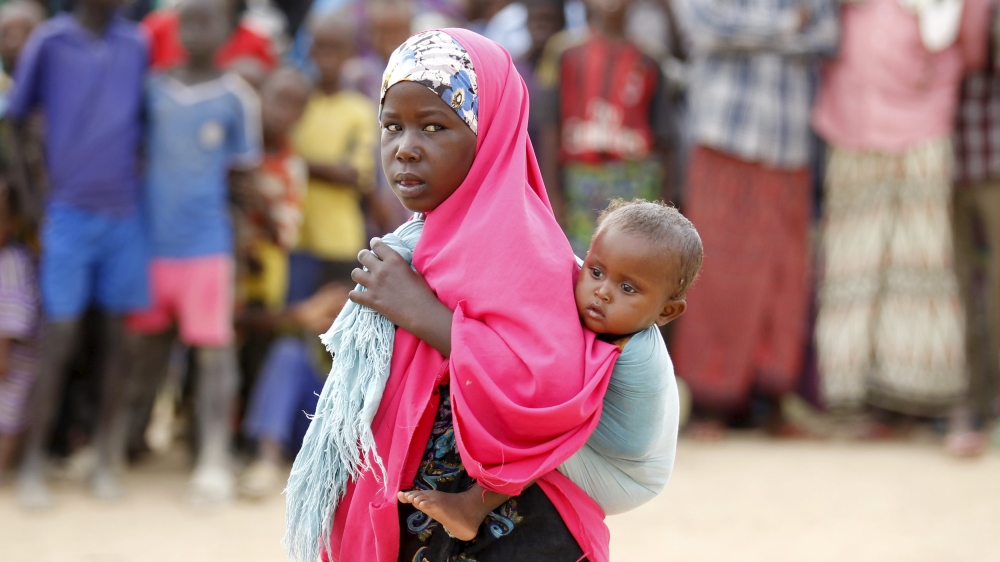 A Somali refugee child carries her sibling at the Ifo camp in Dadaab near the Kenya-Somalia border [Reuters]