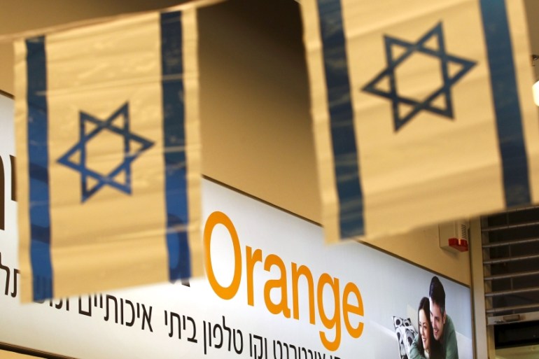 Israeli flags hang next to the logo of Orange mobile company in a store at a Jerusalem mall [REUTERS]
