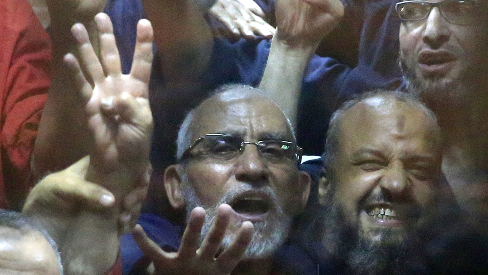 Mohamed Badie and Mohamed el-Beltagy make the four-fingered gesture referring to the 2013 killing of Muslim Brotherhood protesters at the Rabaa al-Adawiya mosque [AP]