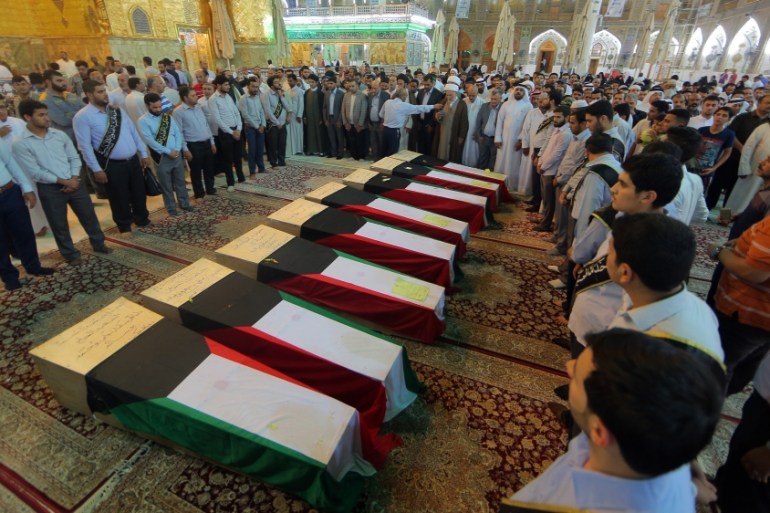 People pray in front of coffins draped with Kuwaiti flags belonging to victims of a suicide bombing that targeted a Shia mosque in Kuwait [AP]
