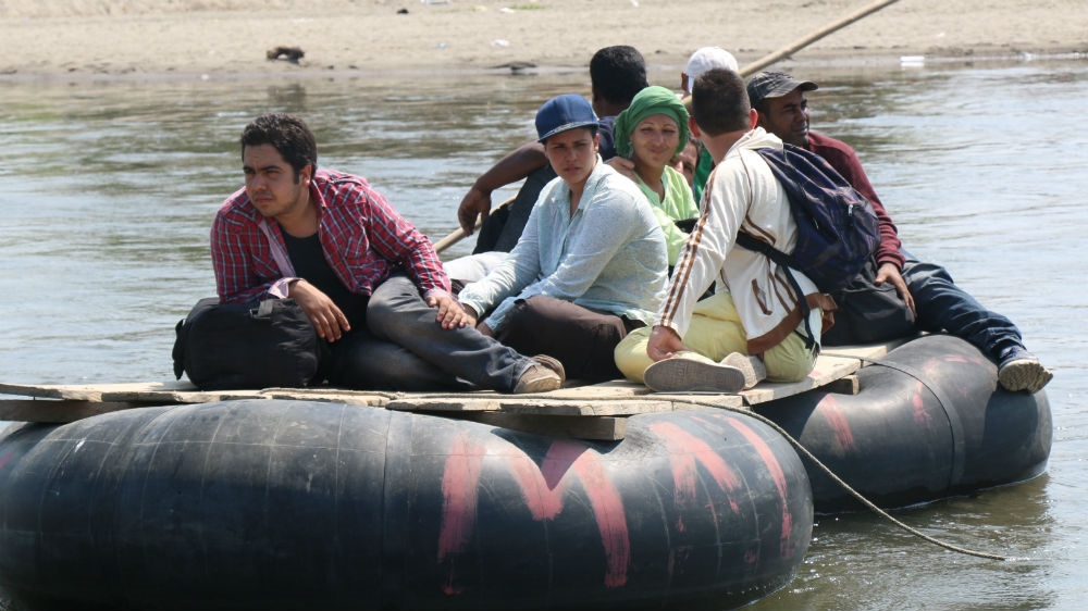 Angel Fernandez, a 25-year-old Cuban migrant in red chequered shirt, leads a group of seven others on their crossing of the Suchiate river along the Guatemala-Mexico border [Amparo Rodriguez/Al Jazeera]