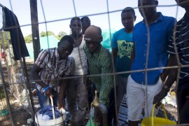 Foreign men queue to board queue for water in a camp for those affected by anti-immigrant violence in Chatsworth north of Durban